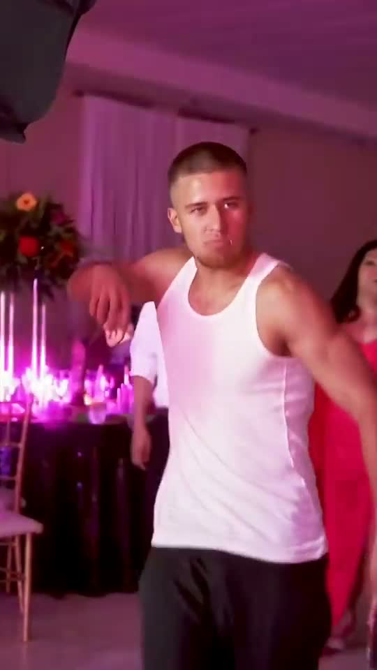 A party guest in a white vest posing with a confident expression